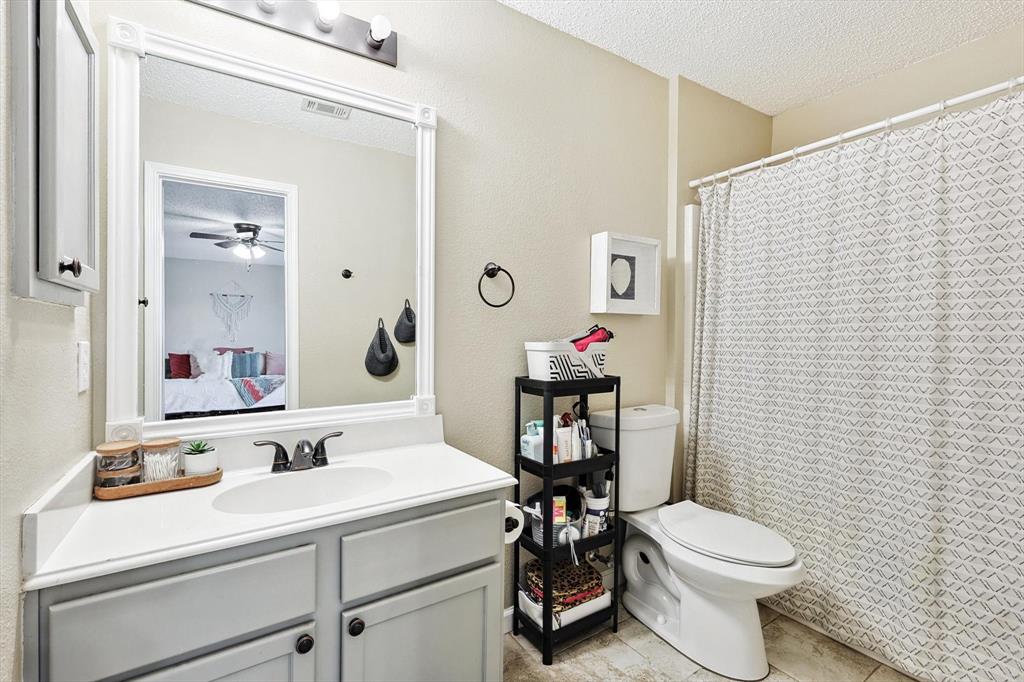 1016 Ridgetop Drive Justin, TX 76247 - Photo 27 of 40 Full bathroom featuring a textured ceiling, vanity, tile patterned flooring, ceiling fan, and curtained shower