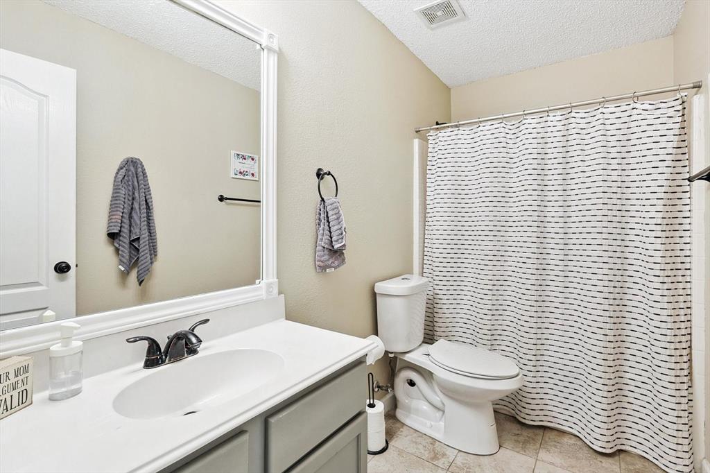 1016 Ridgetop Drive Justin, TX 76247 - Photo 28 of 40 Bathroom with a textured ceiling, vanity, tile patterned floors, and a shower with shower curtain