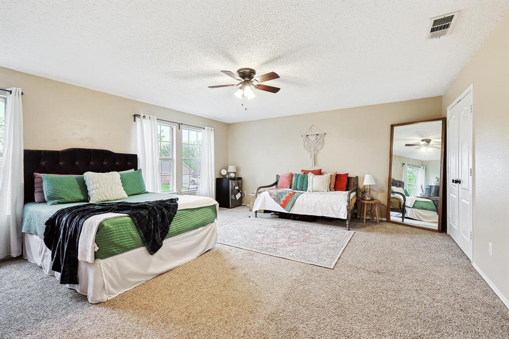 1016 Ridgetop Drive Justin, TX 76247 - Photo 29 of 40 Bedroom featuring a textured ceiling, carpet flooring, and a ceiling fan