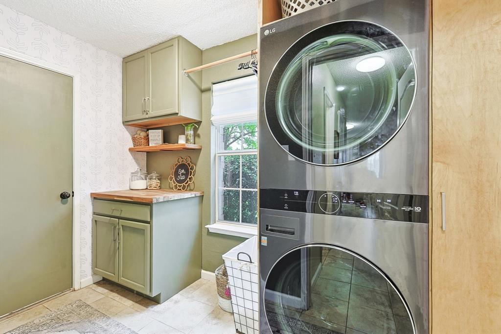 1016 Ridgetop Drive Justin, TX 76247 - Photo 32 of 40 Washroom with stacked washer and clothes dryer, cabinet space, a textured ceiling, and light tile patterned flooring