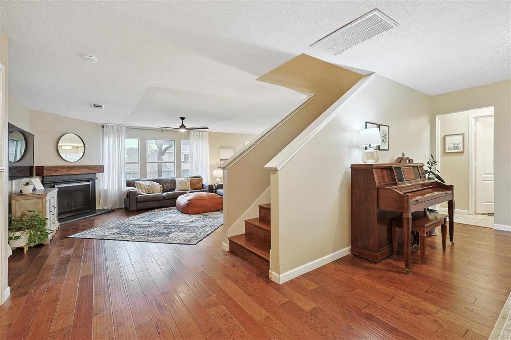 1016 Ridgetop Drive Justin, TX 76247 - Photo 4 of 40 Living area with a textured ceiling, stairs, a fireplace, and wood-type flooring