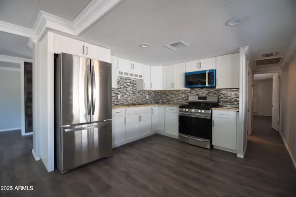 a kitchen with stainless steel appliances granite countertop a refrigerator stove and microwave