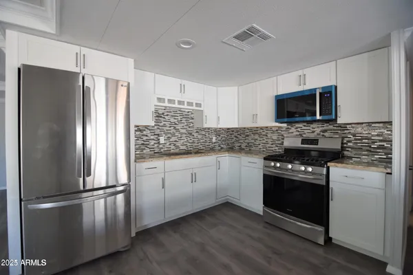 a kitchen with stainless steel appliances a refrigerator stove and microwave