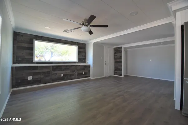 a view of an empty room with a window and a flat screen tv
