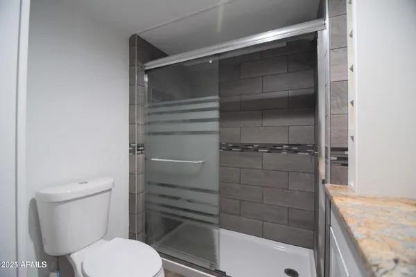 a bathroom with a toilet and a shower