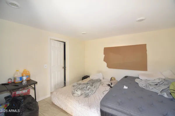 a bedroom with a bed and a wooden floor