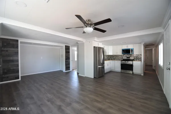 a view of a kitchen with a sink refrigerator and wooden floor