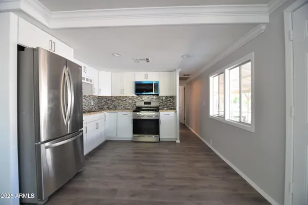 a kitchen with stainless steel appliances a refrigerator sink and microwave