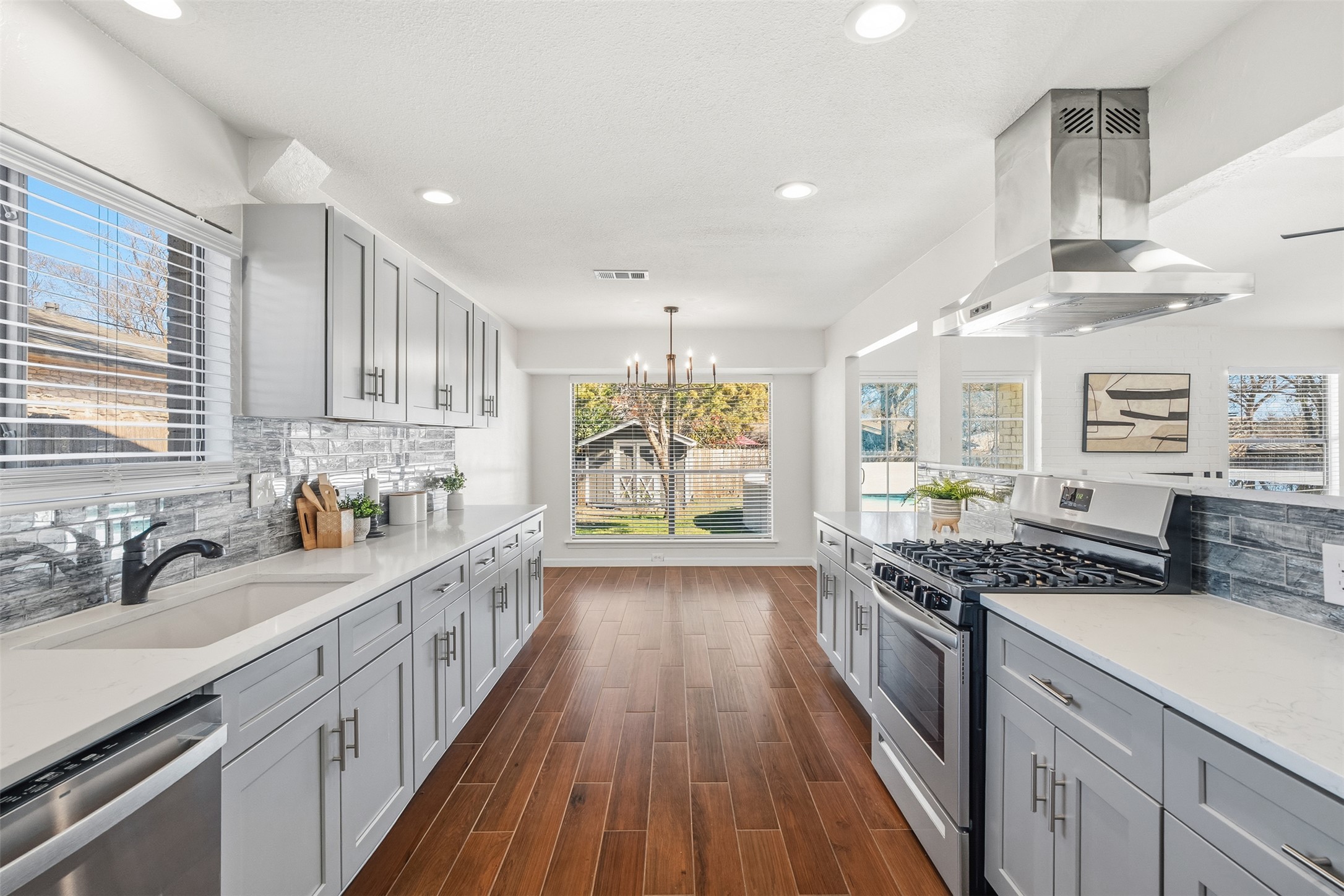 12401 Rusted Nail Cove Austin, TX 78750 - Photo 11 of 34 Kitchen featuring decorative backsplash, gray cabinets, stainless steel appliances, light stone countertops, and recessed lighting