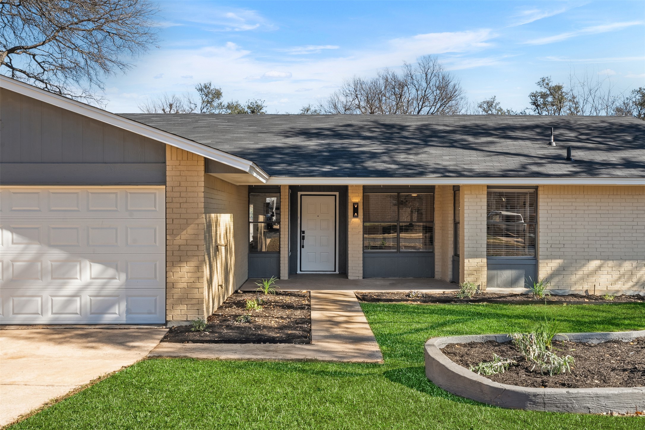 12401 Rusted Nail Cove Austin, TX 78750 - Photo 2 of 34 Property entrance featuring a shingled roof, brick siding, covered porch, and a lawn