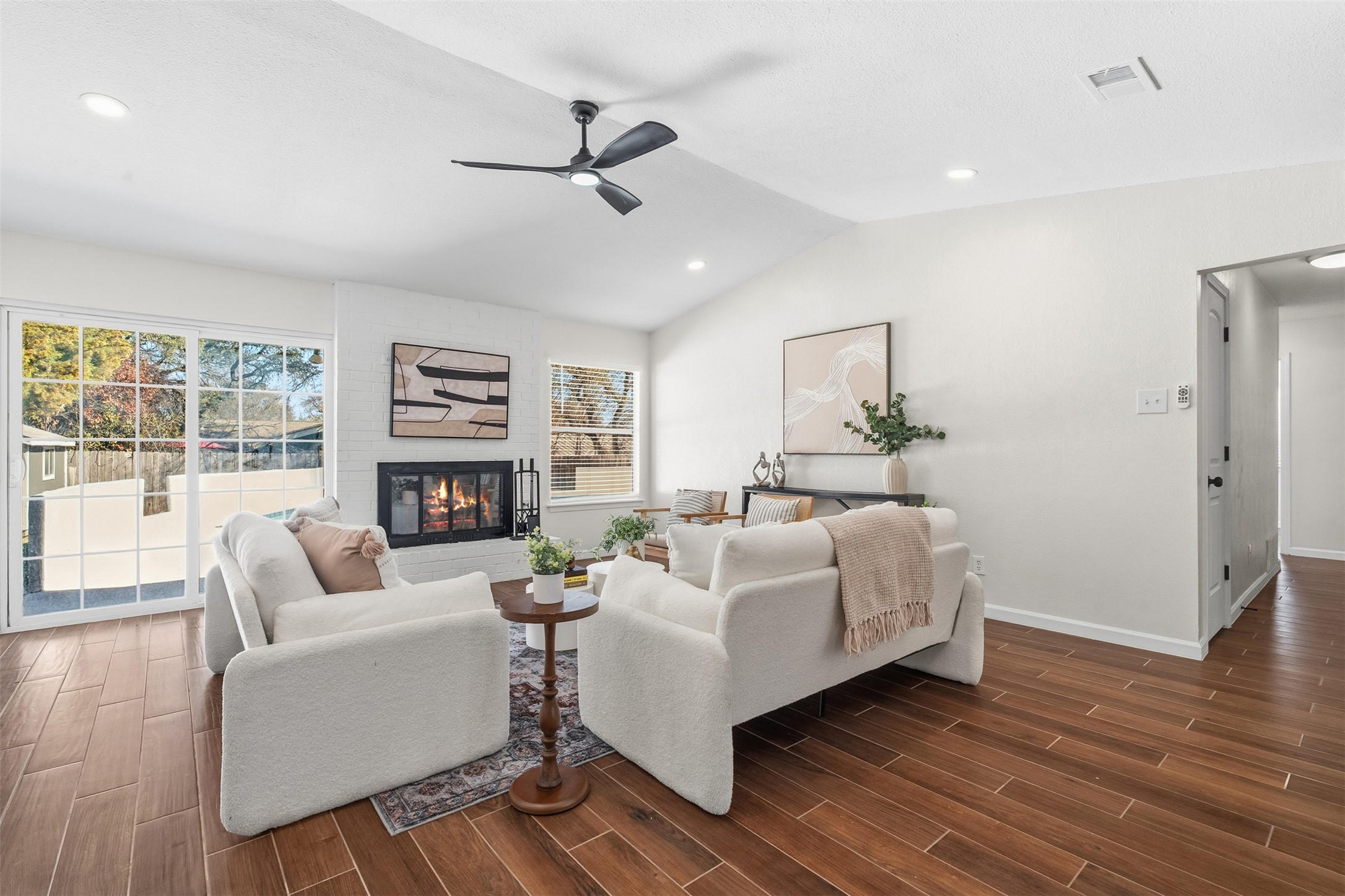 12401 Rusted Nail Cove Austin, TX 78750 - Photo 7 of 34 Living room featuring lofted ceiling, wood tiled floors, a large fireplace, a ceiling fan, and recessed lighting