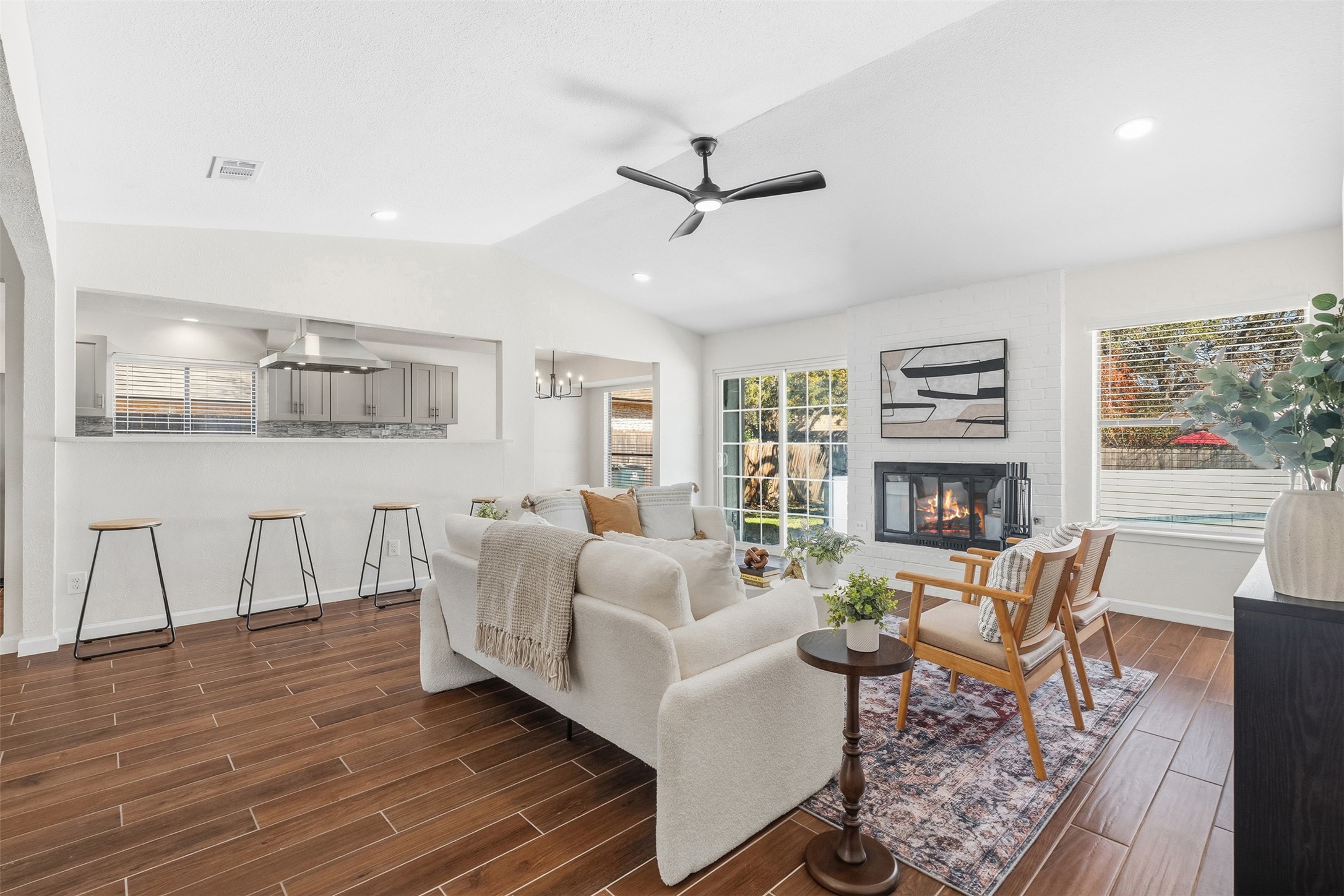 12401 Rusted Nail Cove Austin, TX 78750 - Photo 9 of 34 Living room featuring a large fireplace, wood tiled floors, vaulted ceiling, ceiling fan, and recessed lighting
