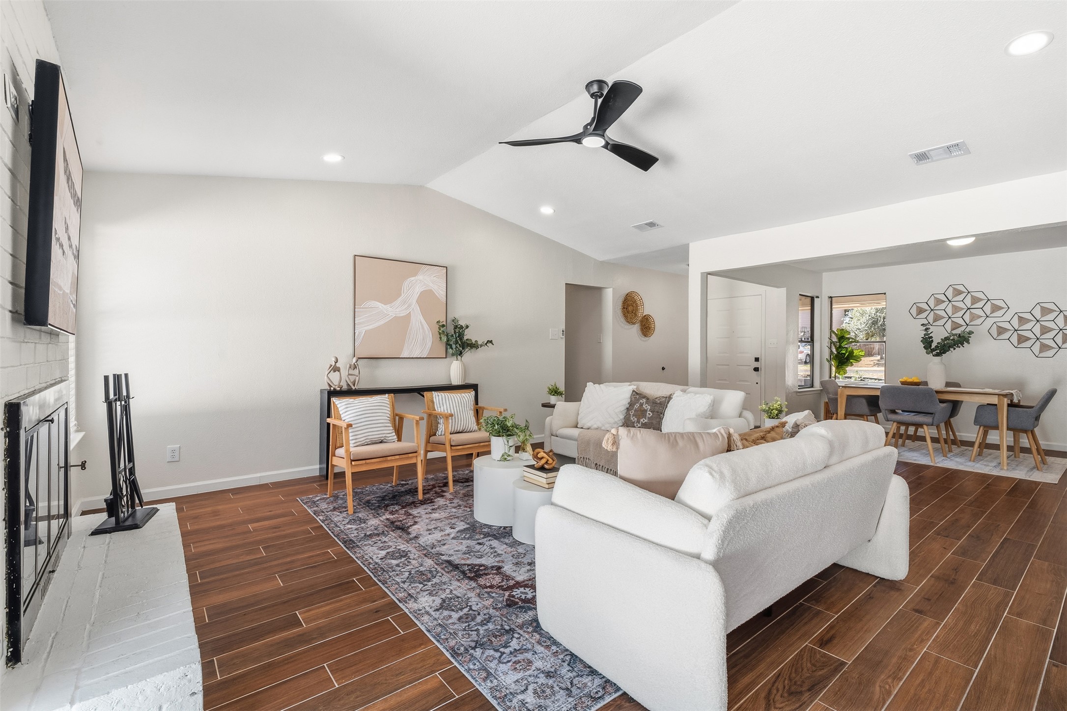 12401 Rusted Nail Cove Austin, TX 78750 - Photo 10 of 34 Living area featuring wood tiled floors, lofted ceiling, a brick fireplace, a ceiling fan, and recessed lighting