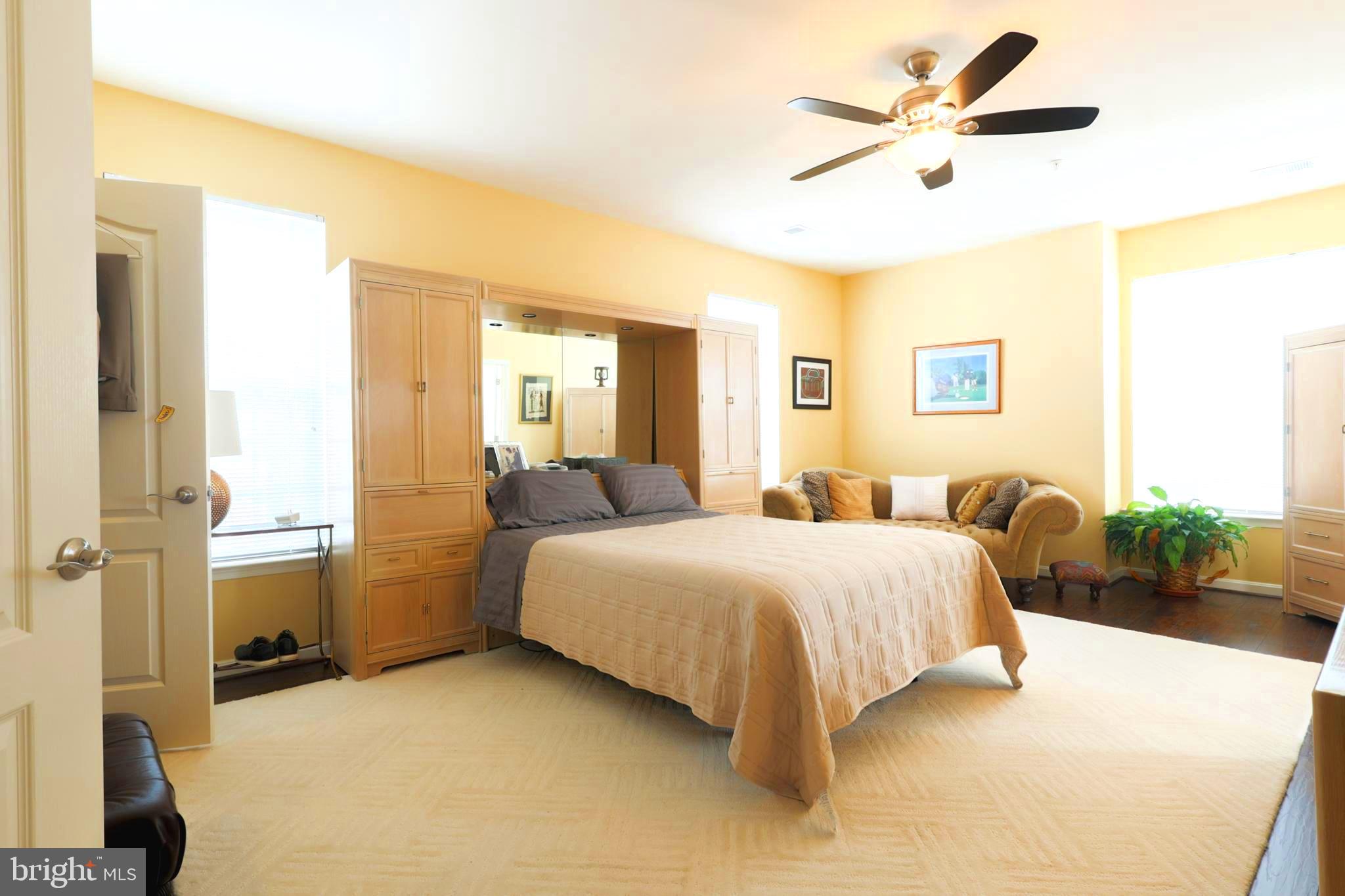 620 Quarry View Court, Unit 407 Reisterstown, MD 21136 - Photo 16 of 25 a spacious bedroom with a bed a couch and a potted plant