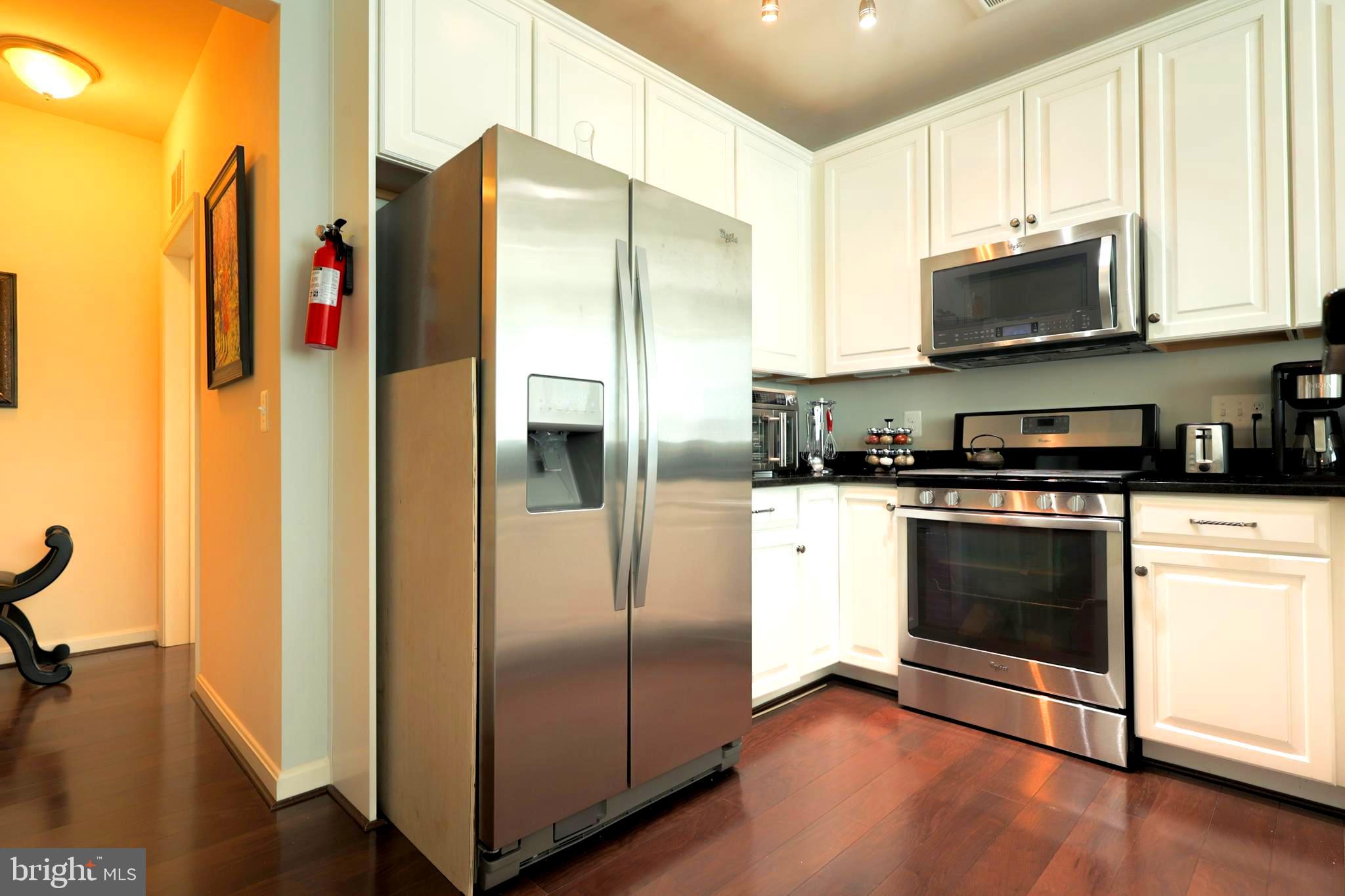 620 Quarry View Court, Unit 407 Reisterstown, MD 21136 - Photo 9 of 25 a kitchen with stainless steel appliances granite countertop a refrigerator and a stove top oven