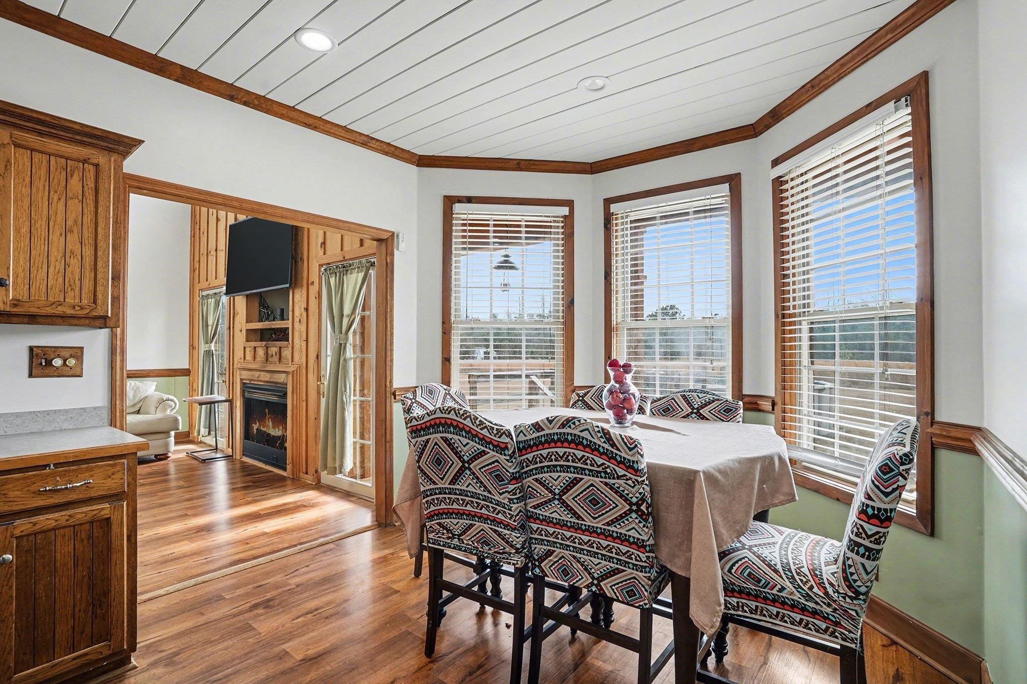 202 Highway 747 Loris Sc 29569 Loris, SC 29569 - Photo 12 of 34 Dining area with light wood finished floors, ornamental molding, and a warm lit fireplace