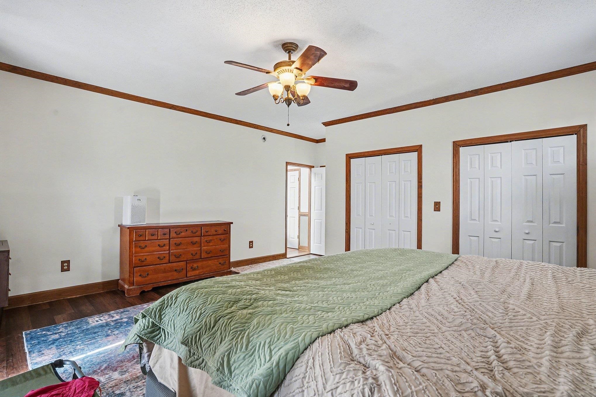 202 Highway 747 Loris Sc 29569 Loris, SC 29569 - Photo 15 of 34 Bedroom featuring multiple closets, crown molding, hardwood / wood-style flooring, and a ceiling fan