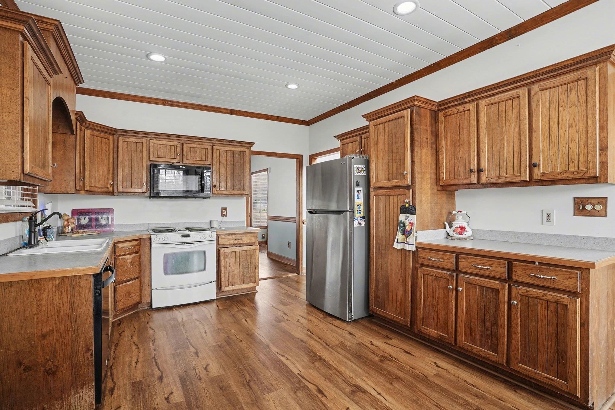 202 Highway 747 Loris Sc 29569 Loris, SC 29569 - Photo 10 of 34 Kitchen featuring light countertops, black appliances, dark wood finished floors, ornamental molding, and recessed lighting