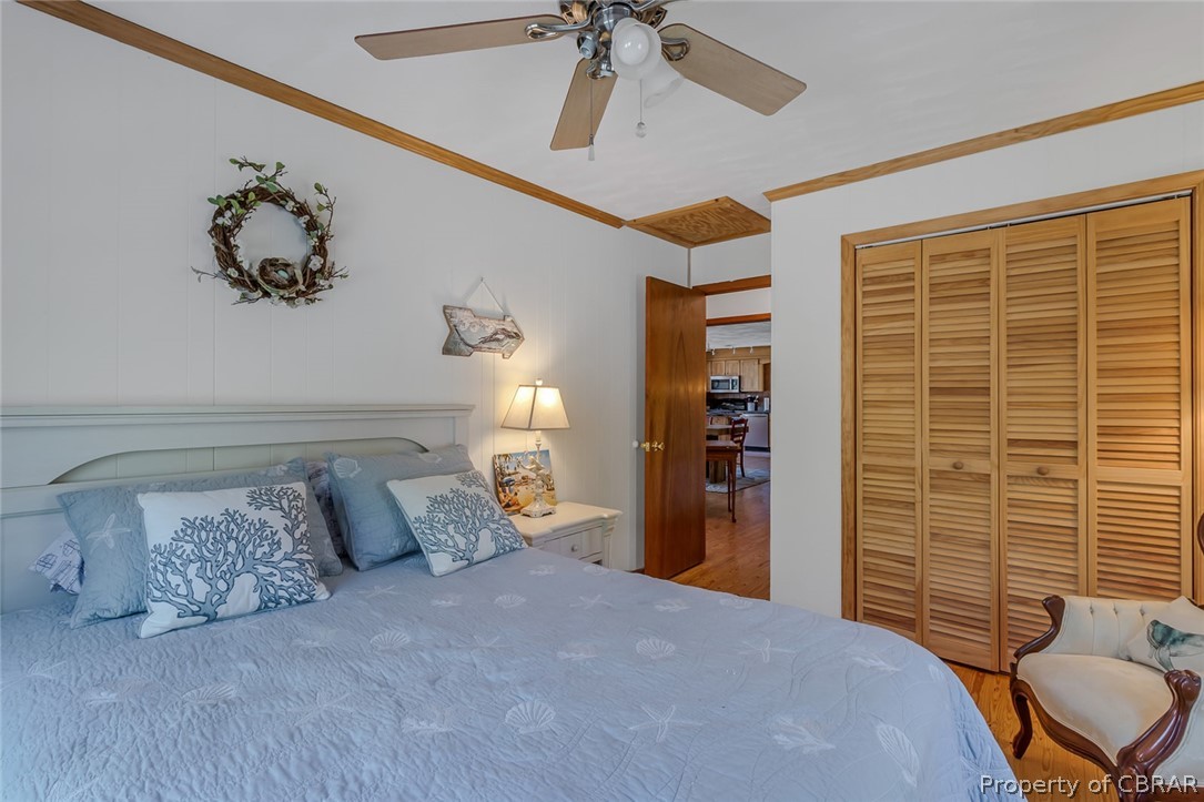 270 Robins Nest Road Lancaster, VA 22503 - Photo 42 of 50 Bedroom featuring hardwood / wood-style floors, a closet, ceiling fan, and crown molding