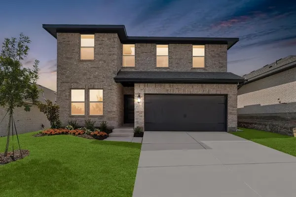 a front view of a house with a garden and yard