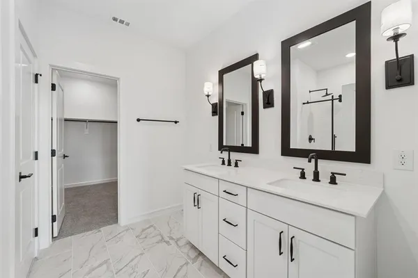 a bathroom with double sink and a mirror