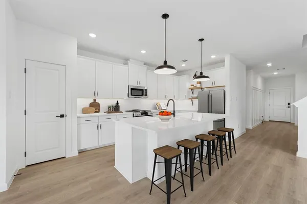 a kitchen with kitchen island white cabinets and stainless steel appliances