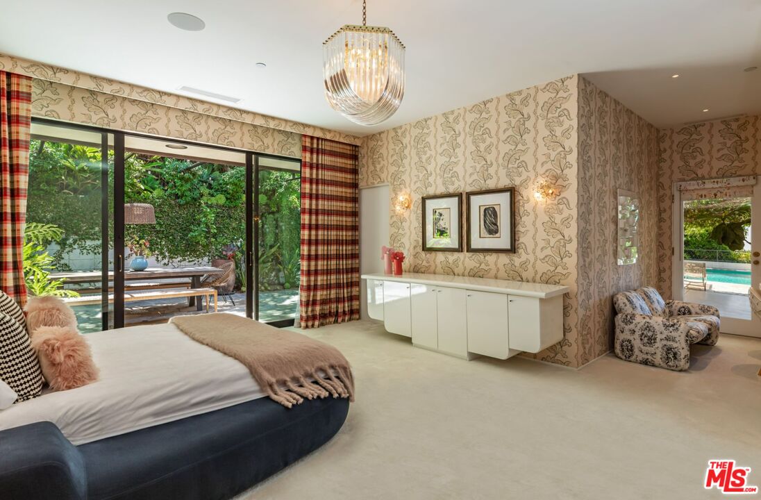 1070 North Hillcrest Road Beverly Hills, CA 90210 - Photo 19 of 29 a bedroom with a large bed and a chandelier
