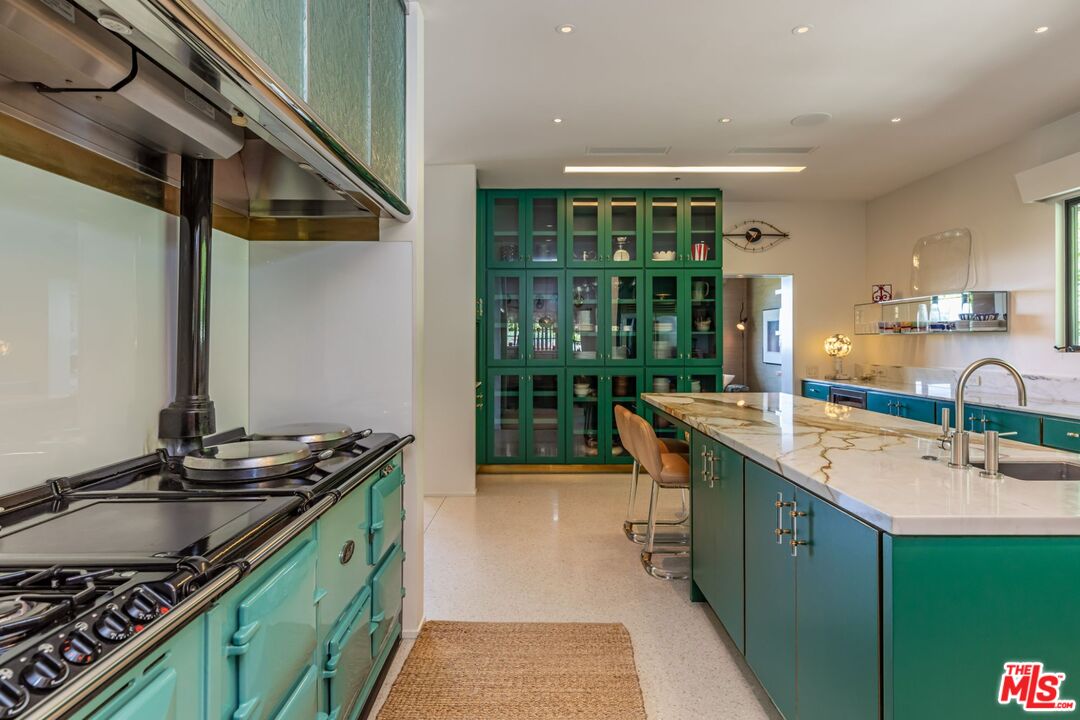 1070 North Hillcrest Road Beverly Hills, CA 90210 - Photo 10 of 29 a kitchen with stainless steel appliances granite countertop a sink and a stove