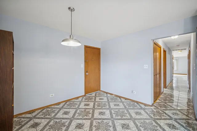 a view of a room with a chandelier fan and wooden floor