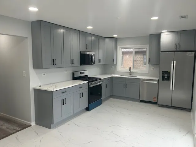 a kitchen with stainless steel appliances a refrigerator sink and microwave