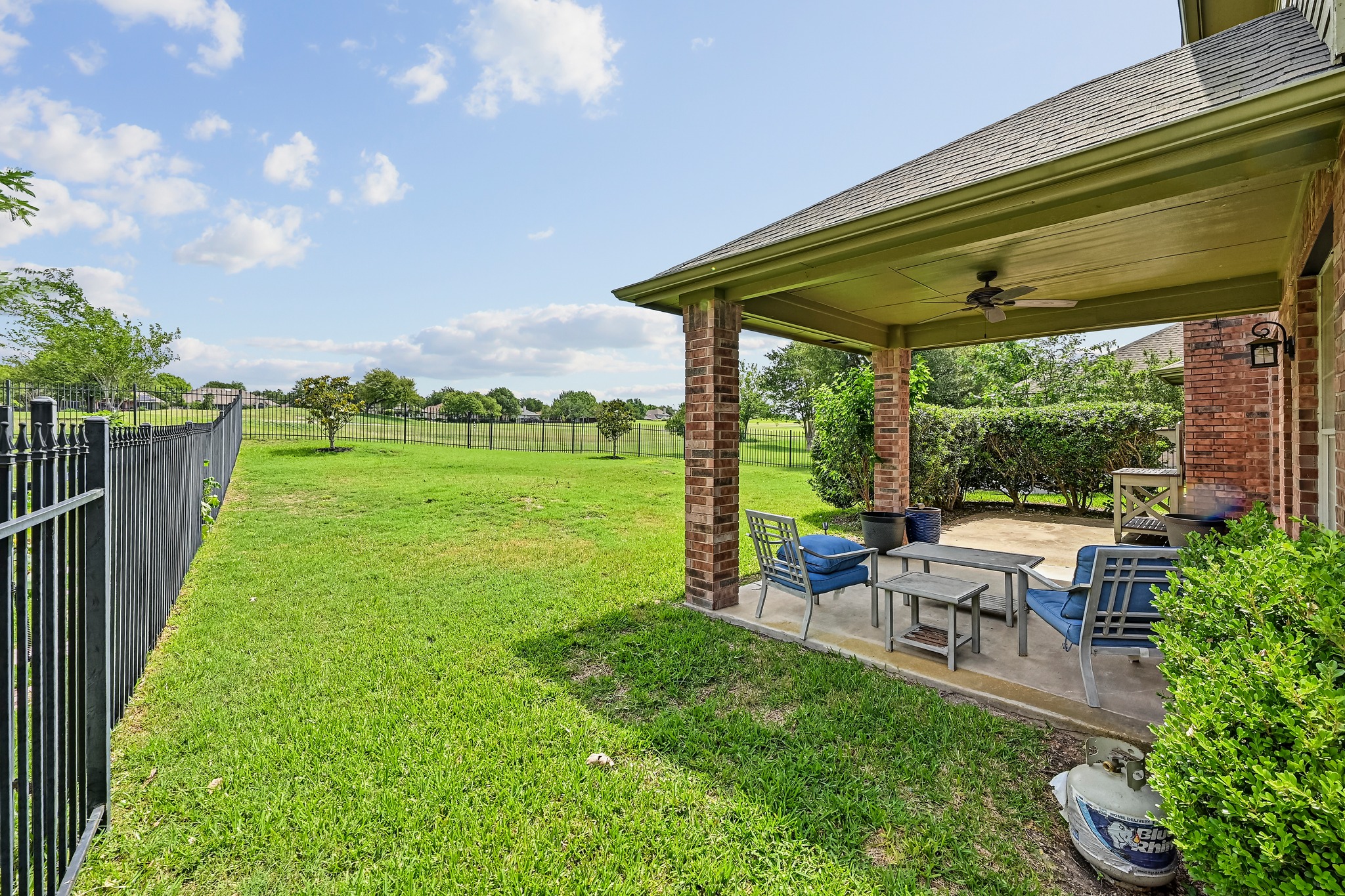 2408 Amen Corner Road Pflugerville, TX 78660 - Photo 36 of 40 Covered patio featuring a ceiling fan, brick columns, and a concrete surface