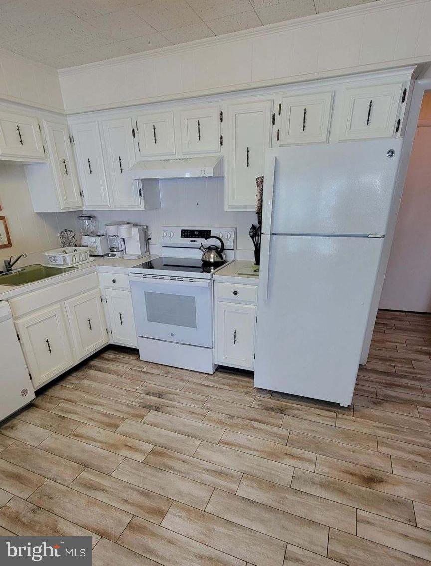 11 91st Street, Unit 102 Ocean City, MD 21842 - Photo 10 of 43 a kitchen with granite countertop white cabinets and white appliances