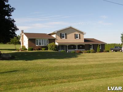 a front view of a house with a yard table and chairs