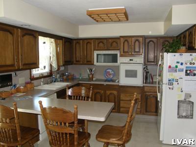 220 Barlieb Road Nazareth, PA 18064 - Photo 4 of 8 a kitchen with stainless steel appliances wooden cabinets a stove a sink and a refrigerator