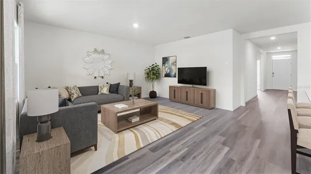 a living room with furniture flat screen tv and wooden floor