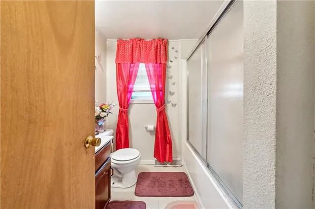 a bathroom with a toilet and a shower curtain