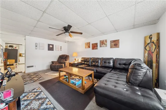 a living room with furniture ceiling fan and a rug