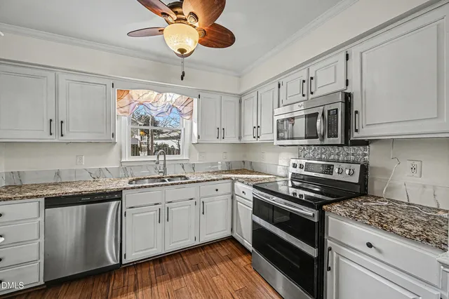 a kitchen with stainless steel appliances granite countertop a sink and cabinets