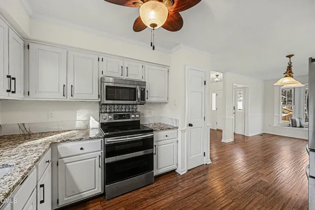 a kitchen with stainless steel appliances a stove a microwave and cabinets