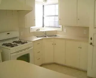 a view of a kitchen with a sink dishwasher and wooden floor