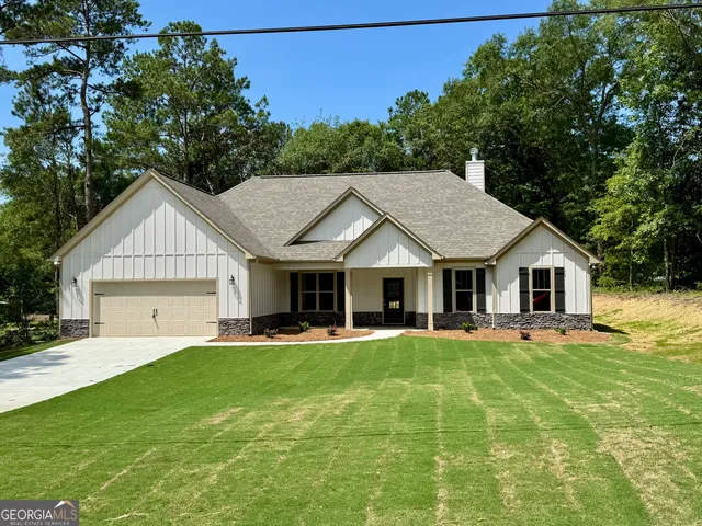 a front view of a house with a yard and trees