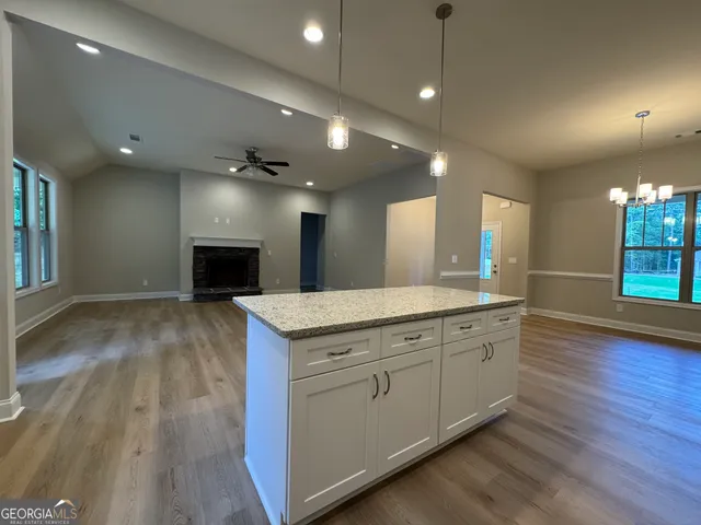 a view of a kitchen center island wooden floor and living room