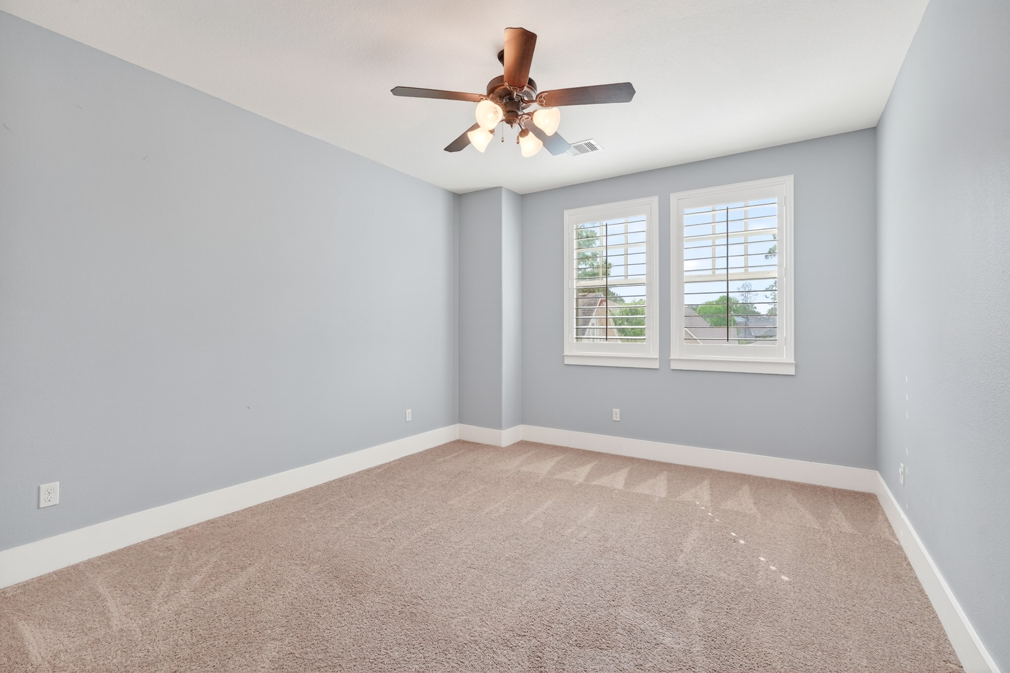 27 Hedgedale Way Spring, TX 77389 - Photo 31 of 43 Original photo shown for reference. Bright and inviting bedroom featuring soft carpeting, a modern ceiling fan, and ample natural light from large windows with plantation shutters.