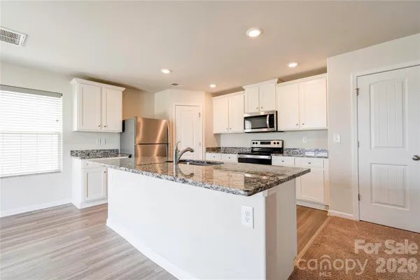 a kitchen with a sink a stove a microwave and cabinets