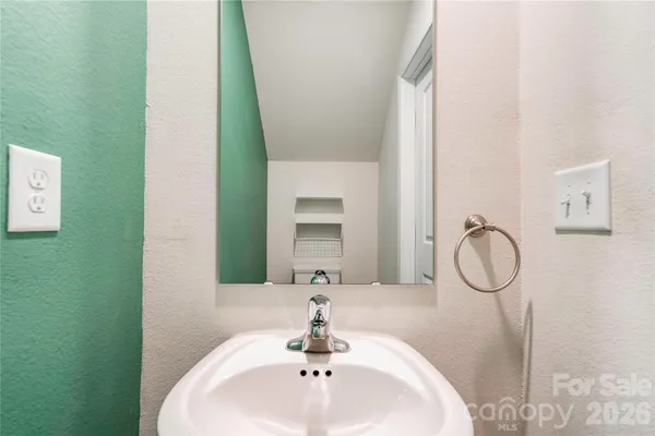 a bathroom with a granite countertop toilet sink and mirror
