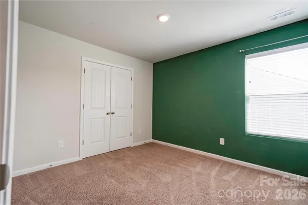a view of an empty room with window and stairs