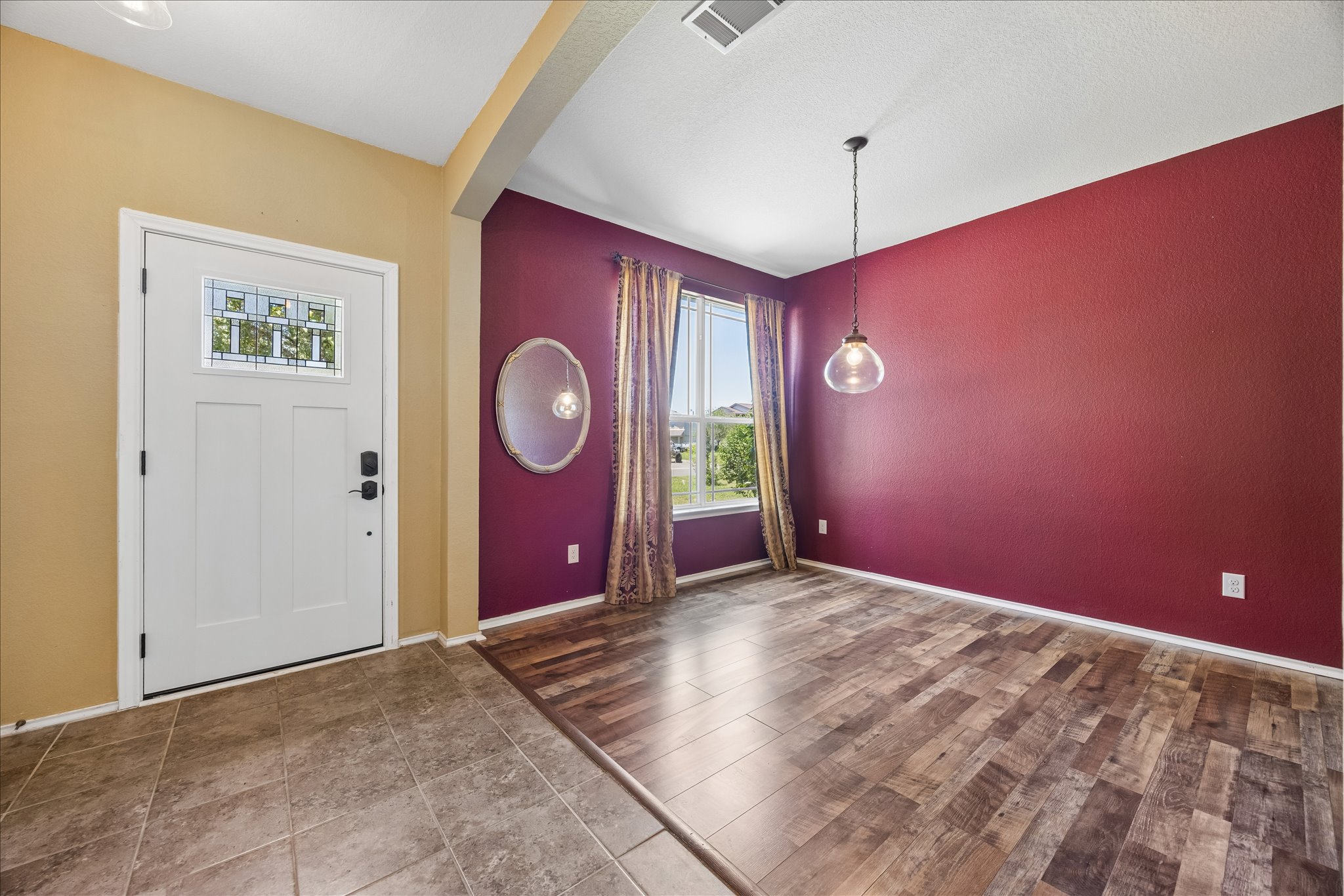 338 Spring Branch Loop Kyle, TX 78640 - Photo 4 of 36 A welcoming entryway transitions into a versatile dining space with wood-look flooring and a modern pendant light.