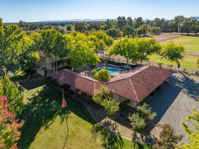 an aerial view of a house with a garden and lake view