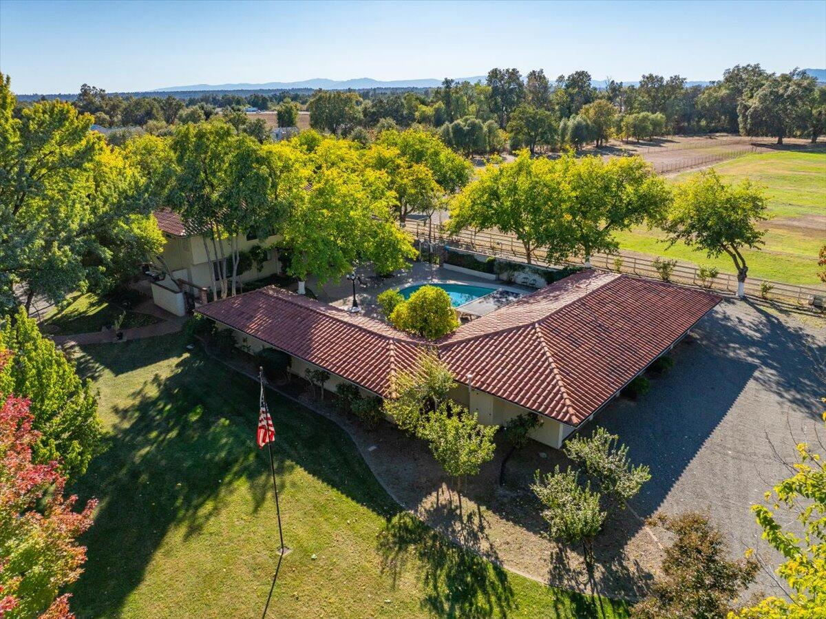 an aerial view of a house with a garden and lake view