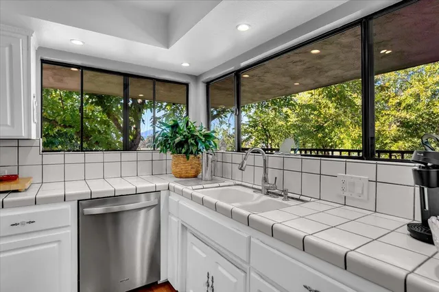 a kitchen with white cabinets and appliances